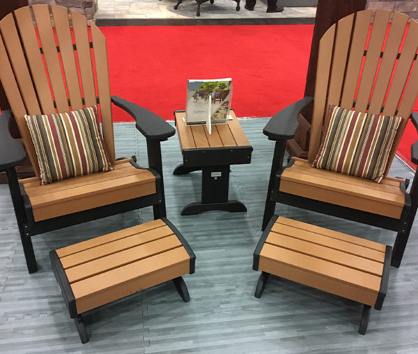 Sixteen inch pillows displayed on Adirondack chairs with foot stools and a side table.